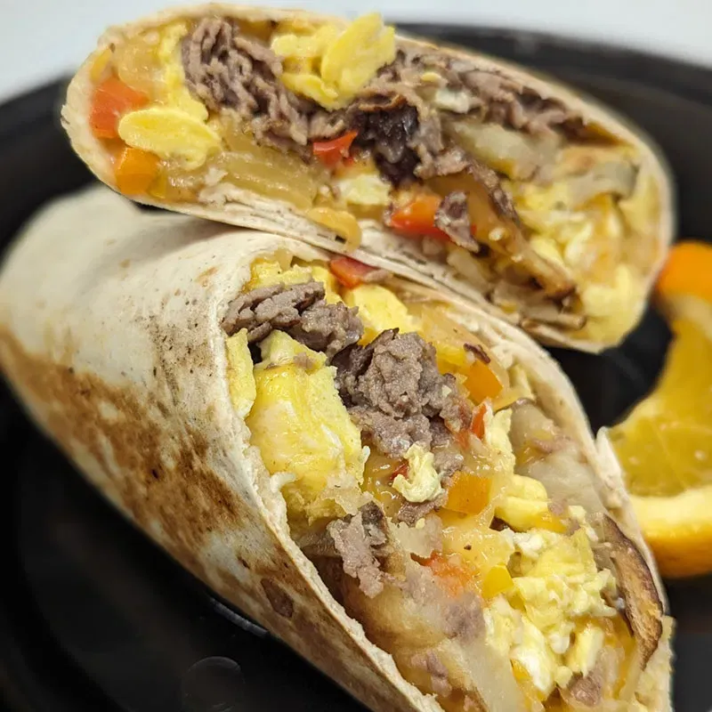 Signature Steak & Egg Burrito with hash browns and melted cheese